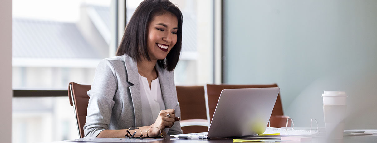 Cheerful young businesswoman on the computer