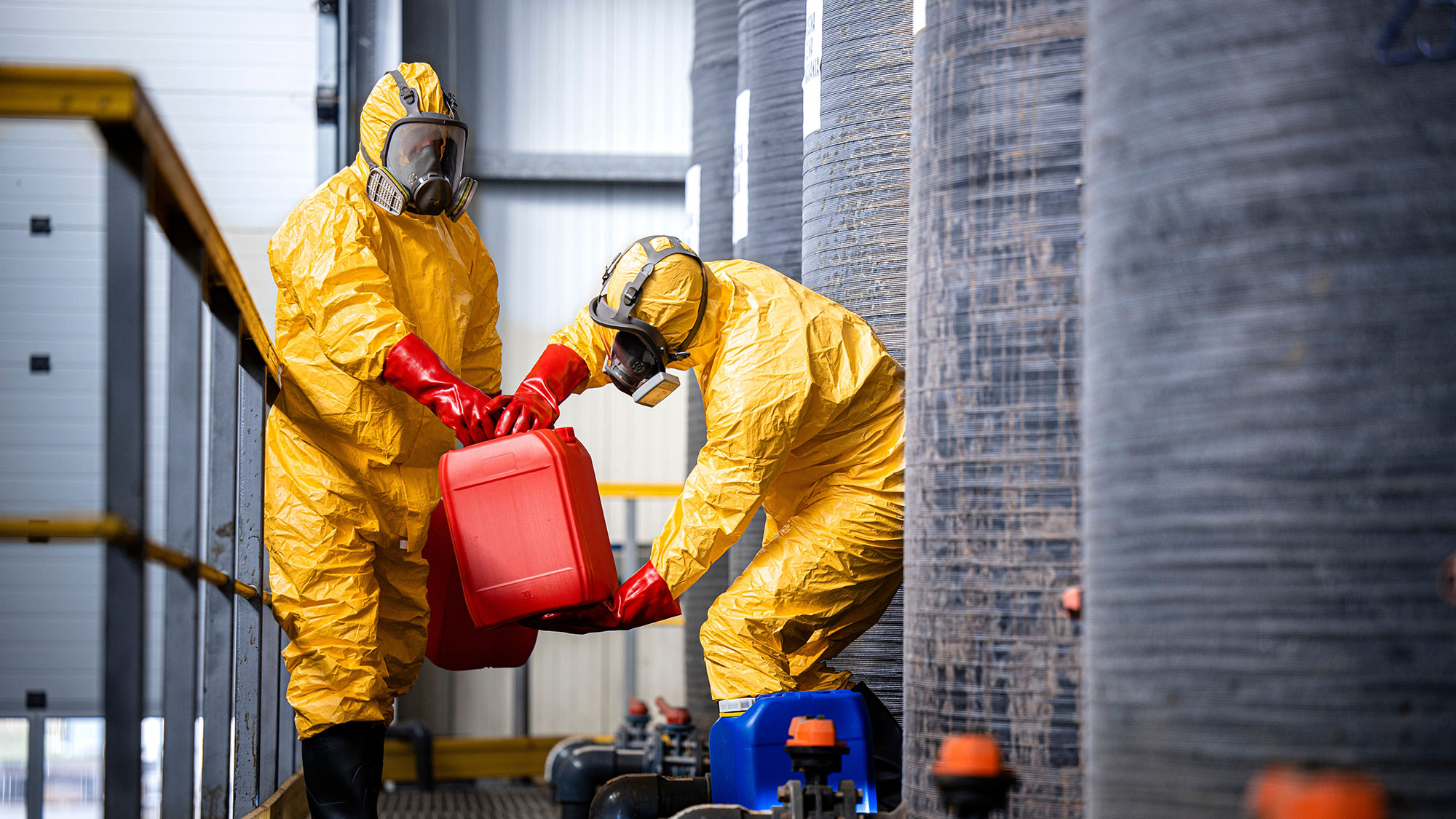 chemical-workers-carrying-canisters-with-hazardous-materials