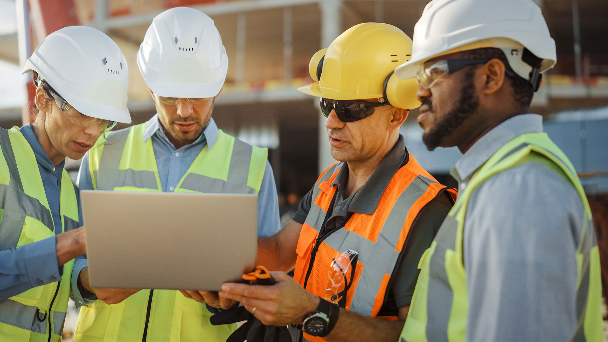 Diverse-Team-of-Specialists-Use-Laptop-Computer-on-Construction-Site