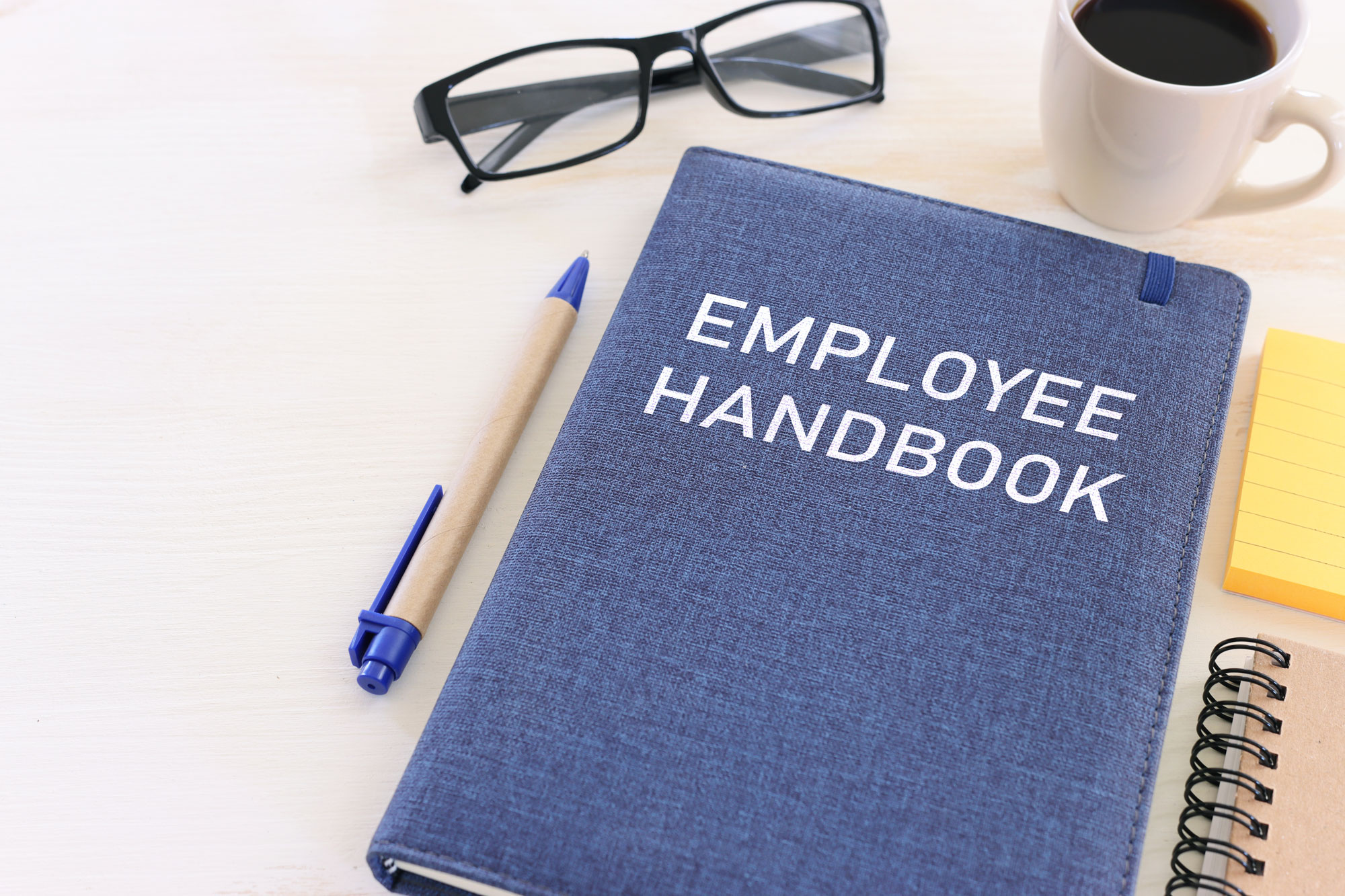 a compliant employer handbook on a desk