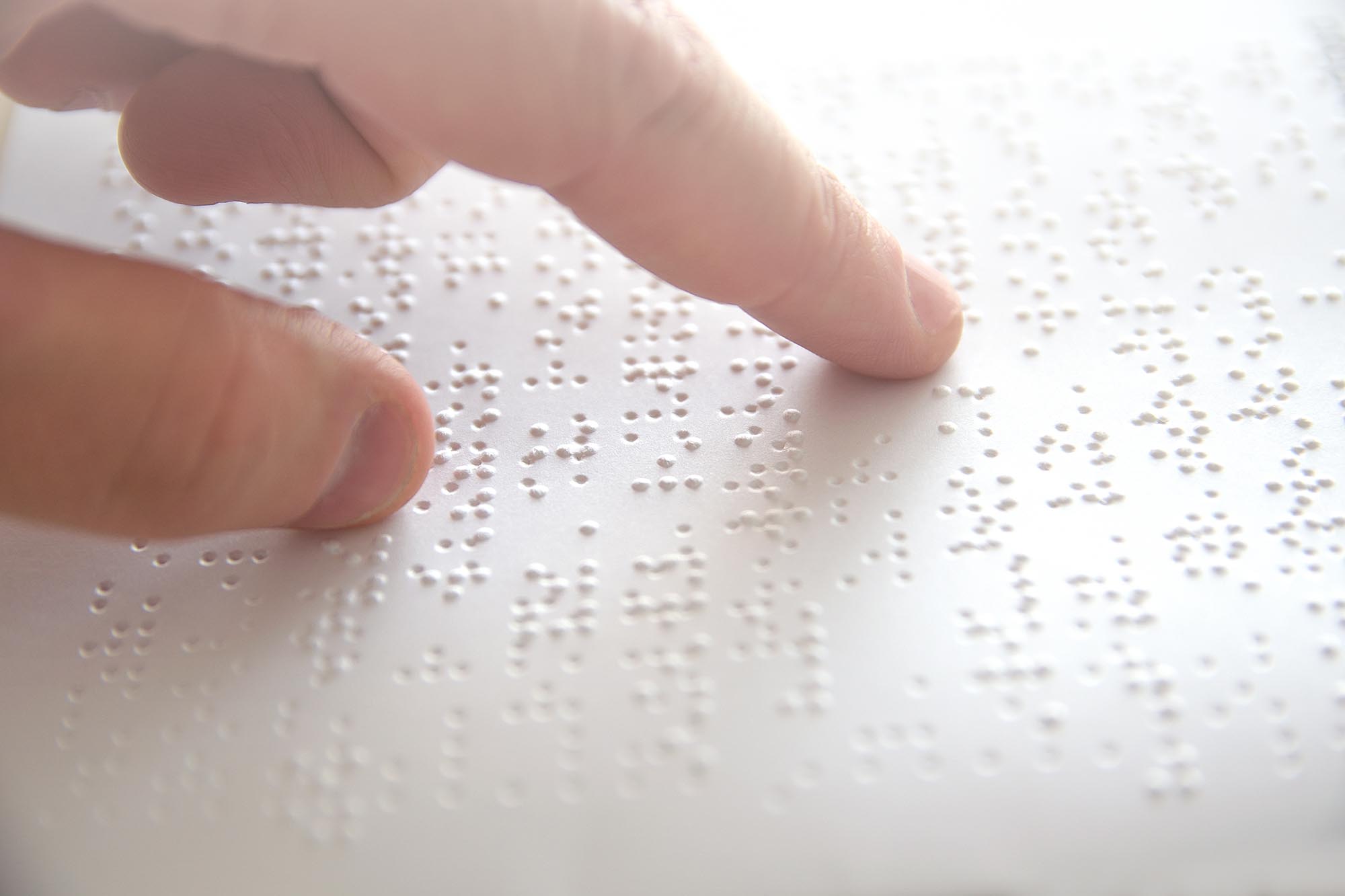 Hand of a blind person reading some braille