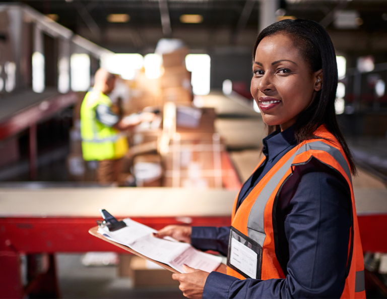 woman-with-clipboard-in-front-of-conveyor-belt