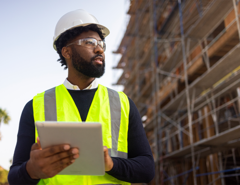 man-in-vest-holding-tablet-looking-right