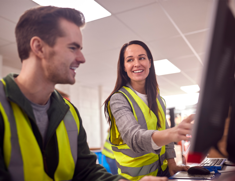 man-and-woman-in-safety-vests-looking-at-screen