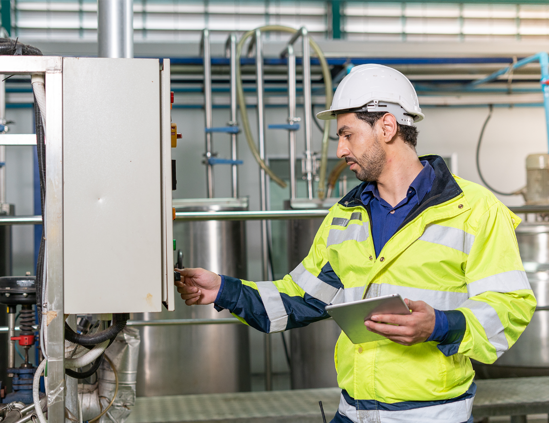 worker-in-hard-hat-and-hi-vis-using-a-tablet-in-a-factory