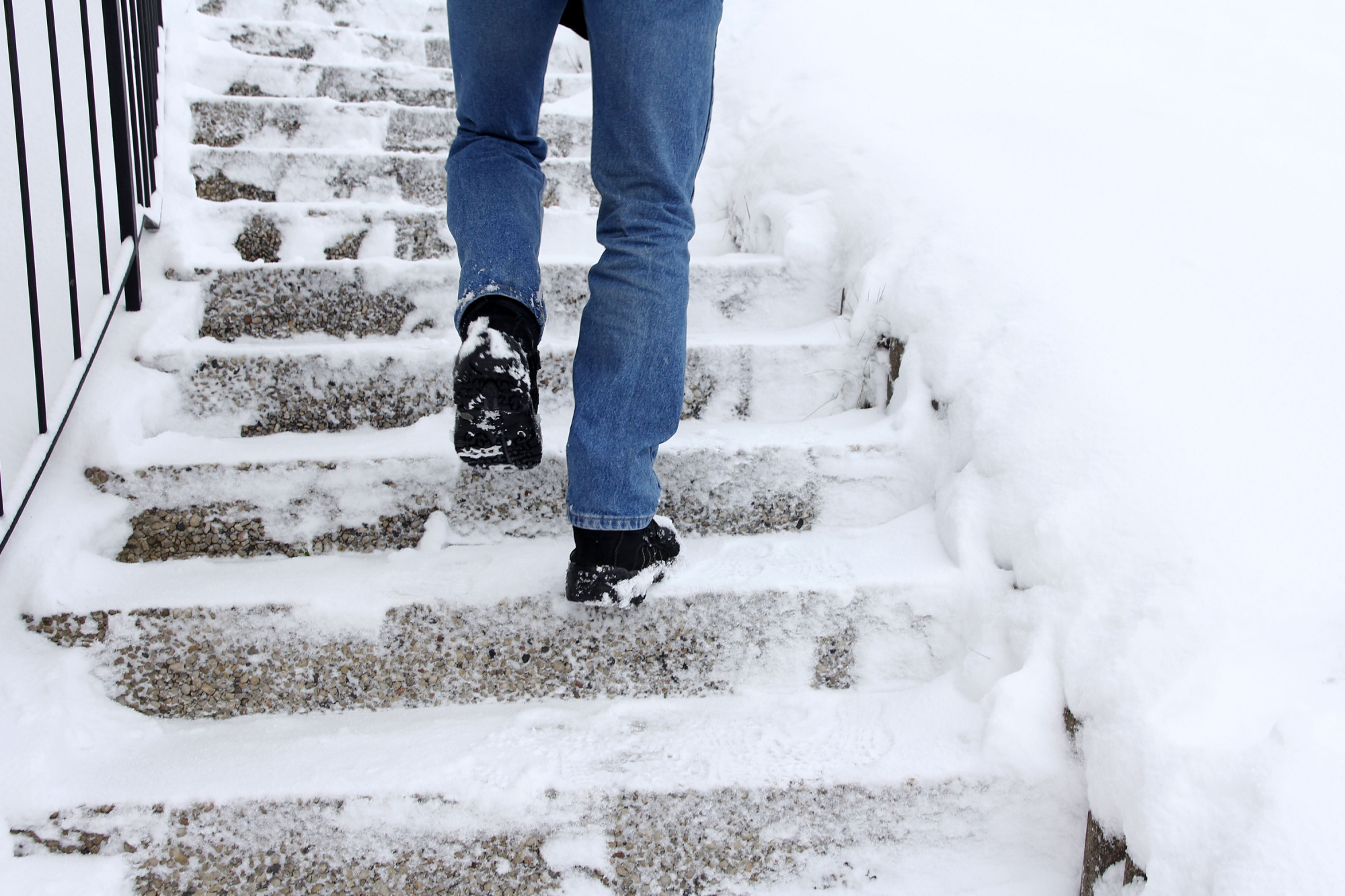 someone walking up snowy and icy concrete stairs