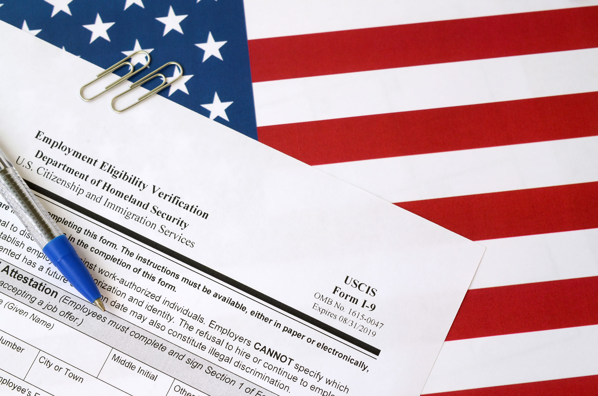 Form I-9 with American flag in the background
