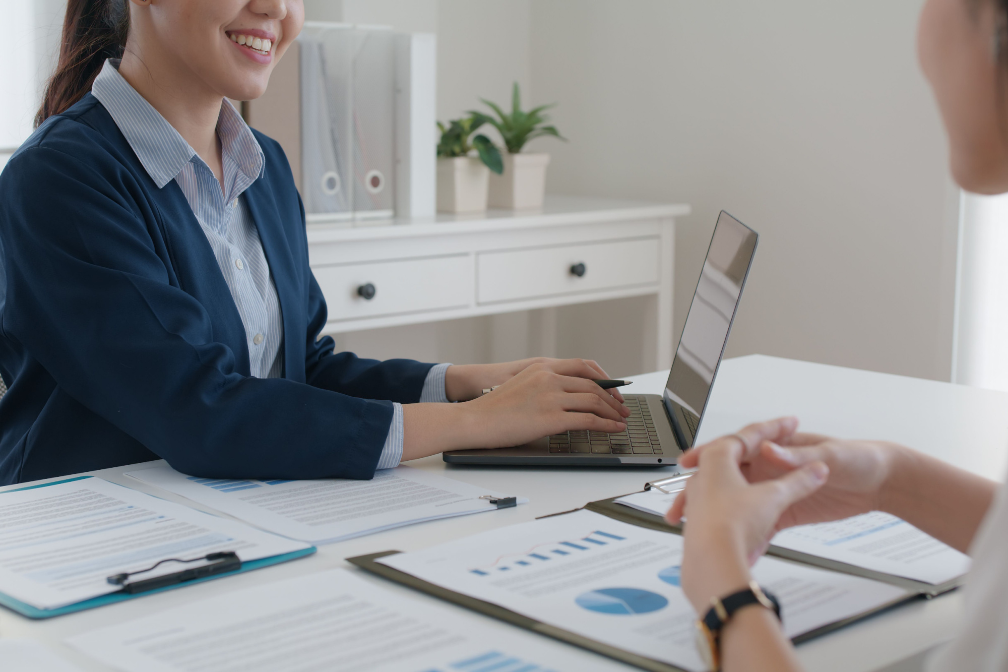 two people sitting at a desk discussing financials