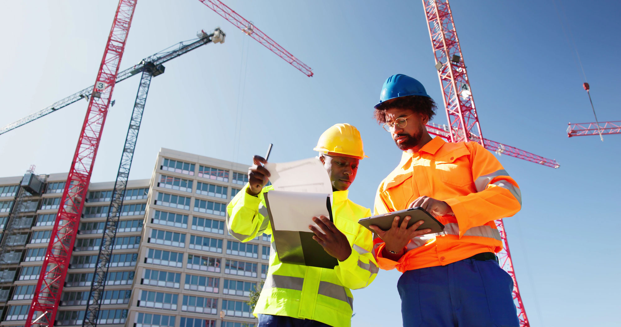 Two construction workers surveying a job site