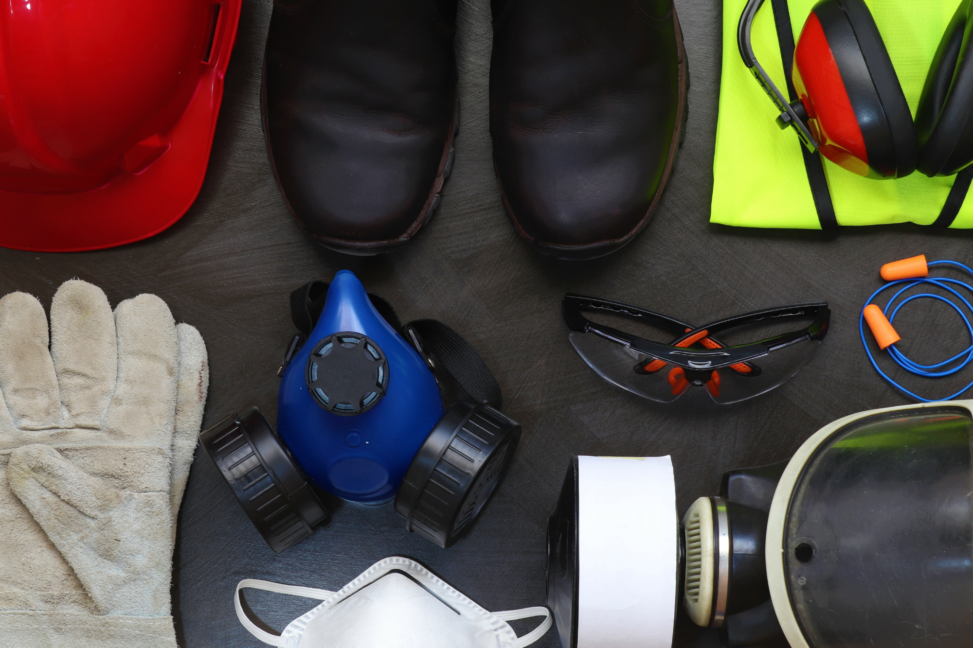 flat lay with gloves, helmet, ear protection, eye protection, and mask