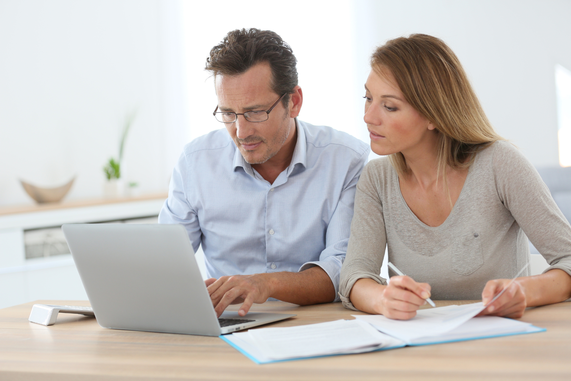 man and woman looking at computer and taking notes