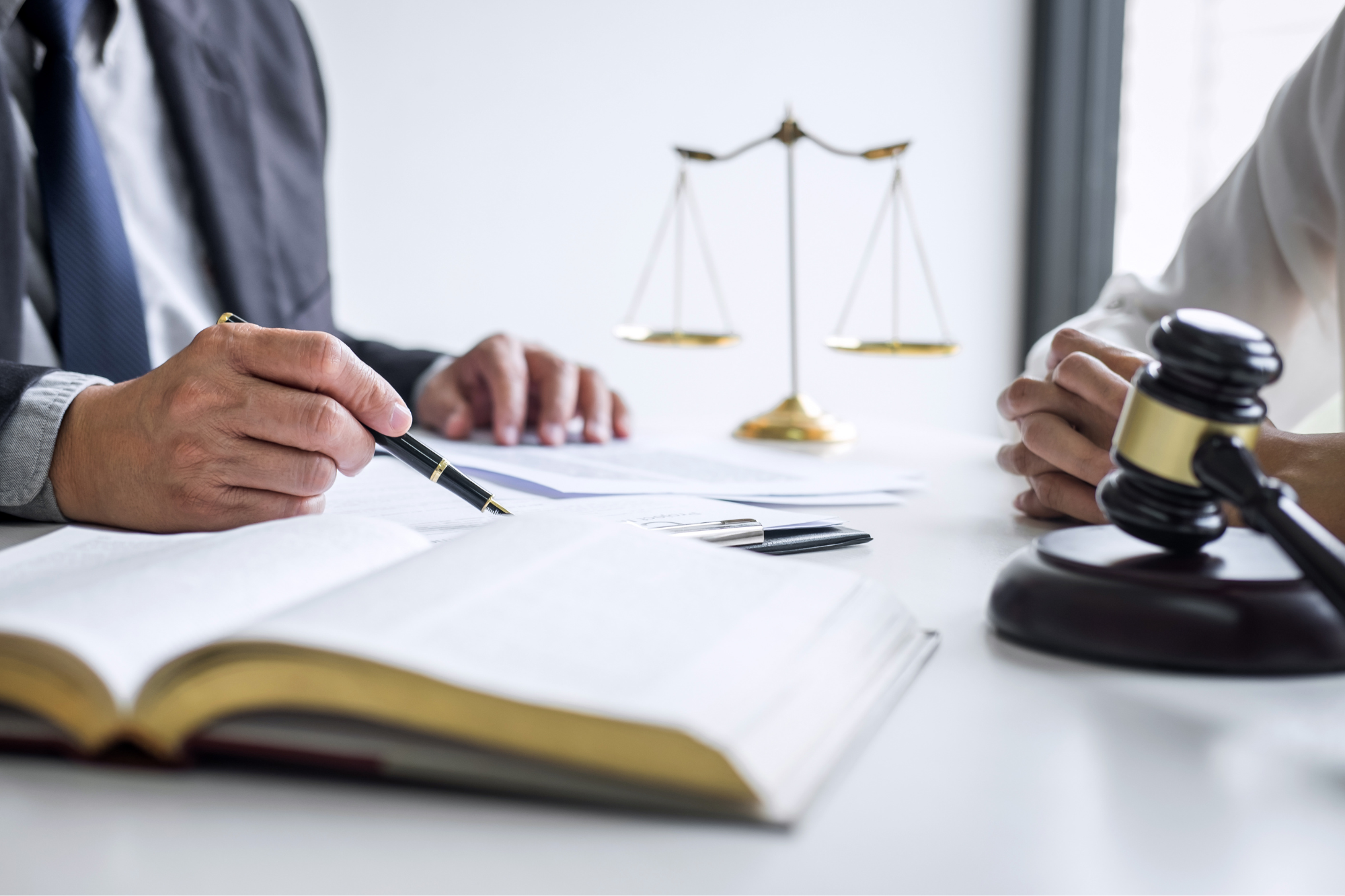 two people reviewing a document with gavel and scale