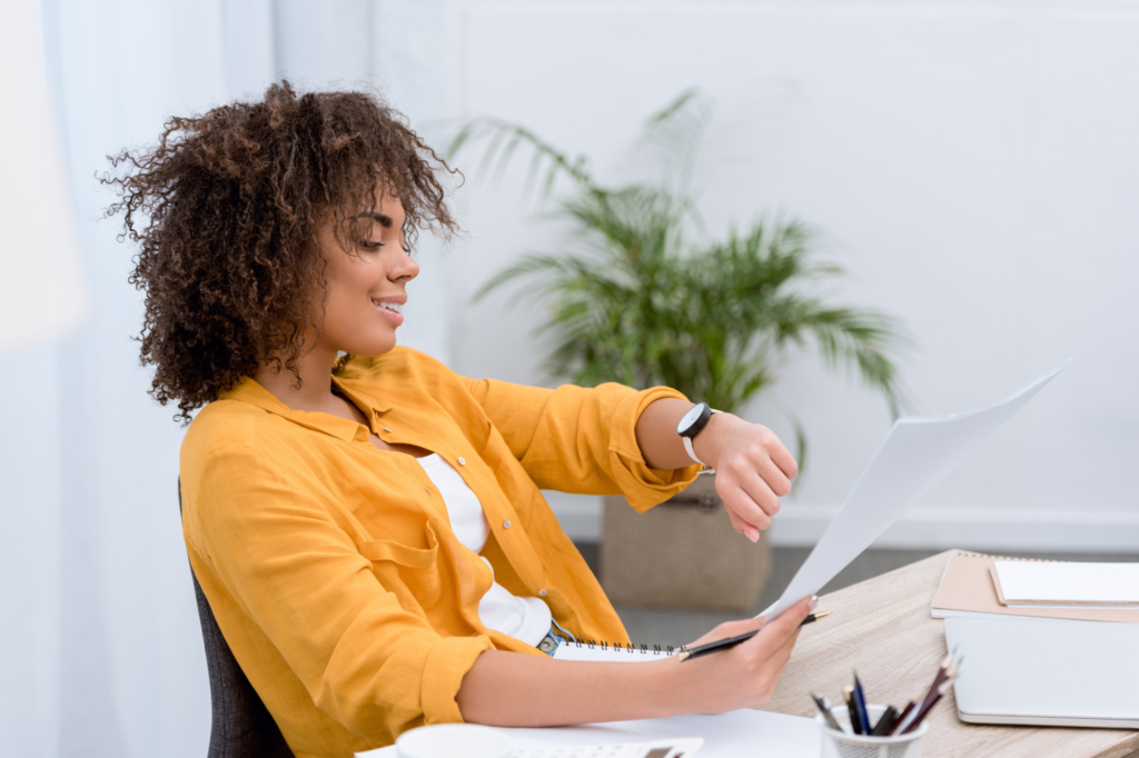 woman working at desk and checking her watch