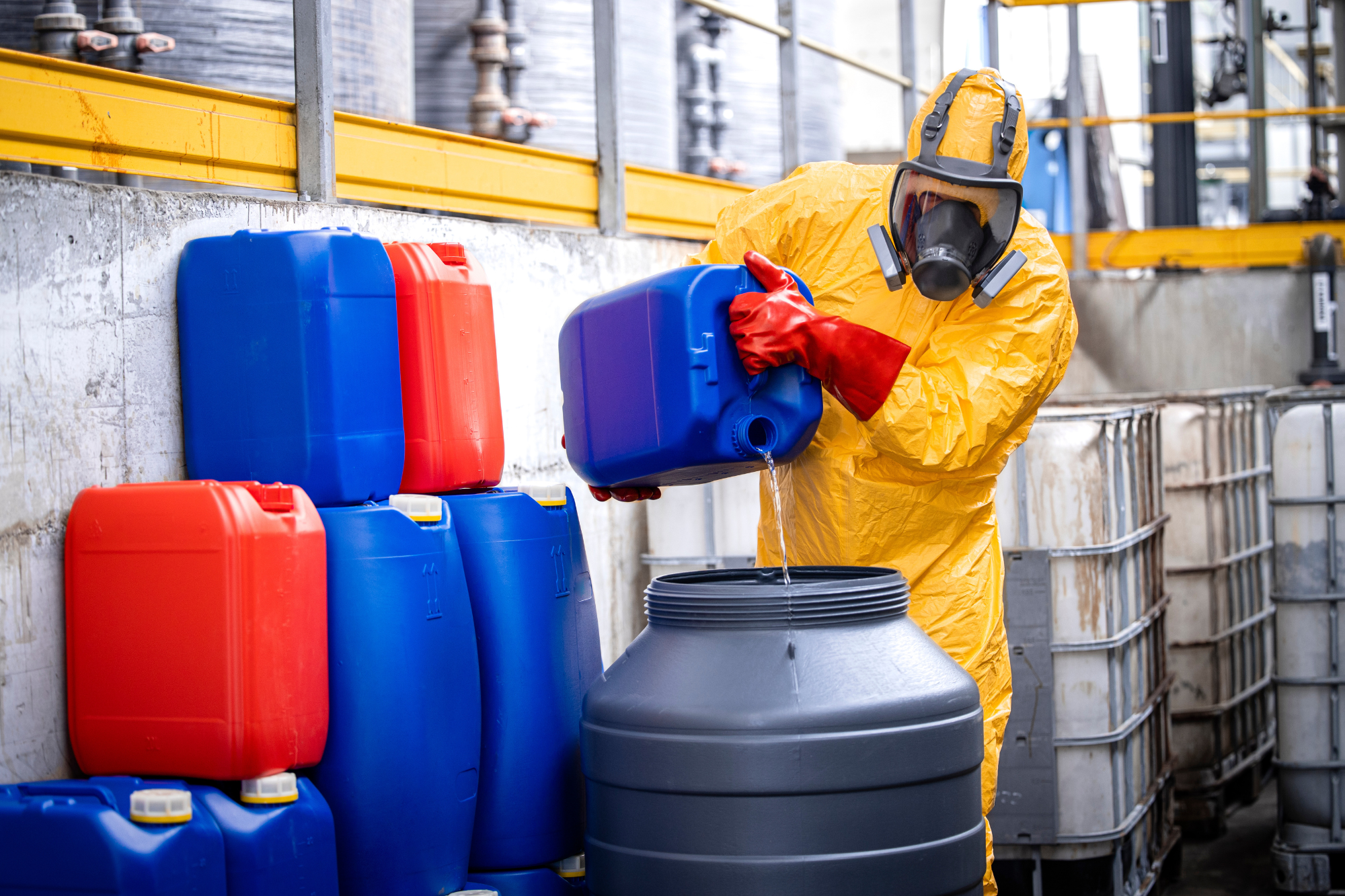 worker wearing ppe transferring chemicals to another container and preventing chemical accidents