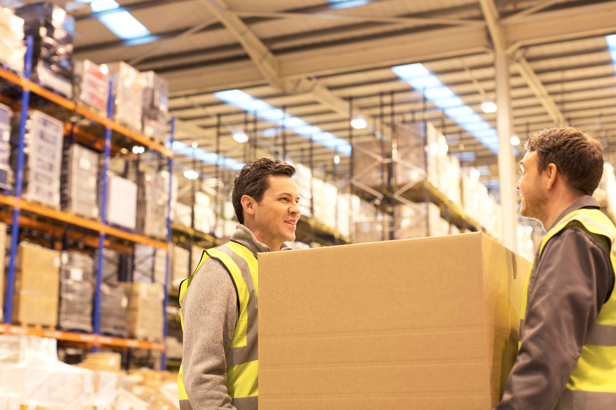 two workers carrying a box together