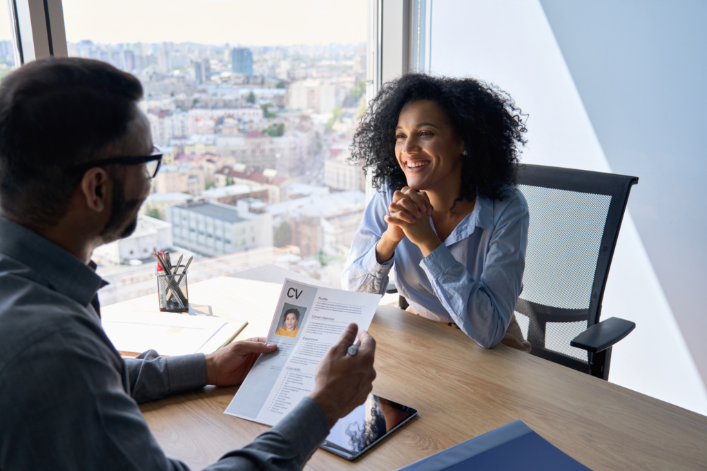 woman being interviewed by man holding her resume