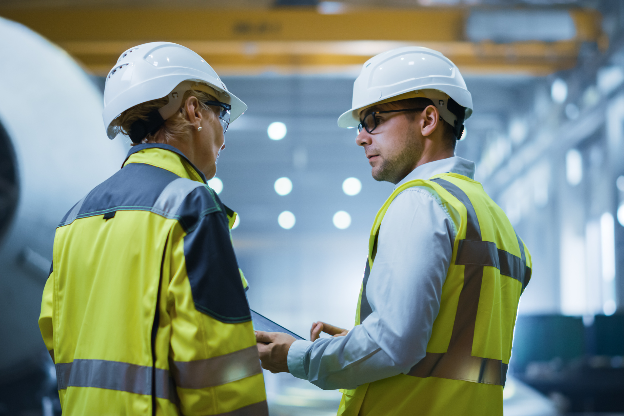 safety inspection taking place with two people wearing yellow safety vests and white hard hats