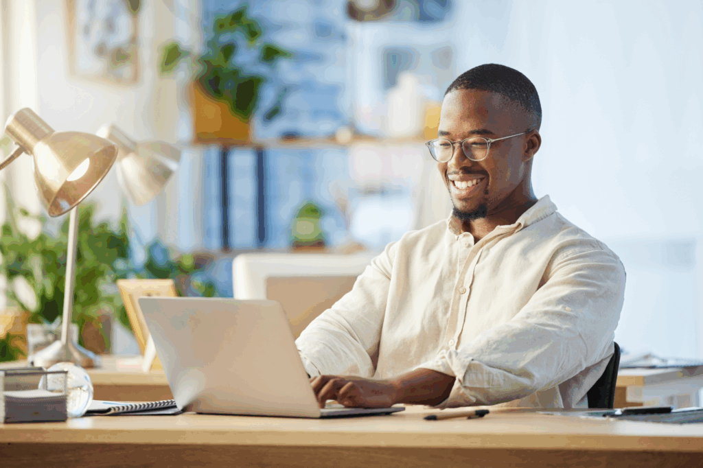 man smiling while typing on a computer in an office