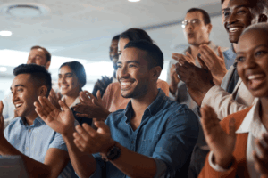 Applause, support and wow with a business team clapping as an audience at a conference or seminar. Meeting, motivation and award with a group of colleagues or employees cheering on an achievement