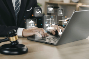 Person on a laptop with a gavel in the foreground and employment law icons hovering above keyboard