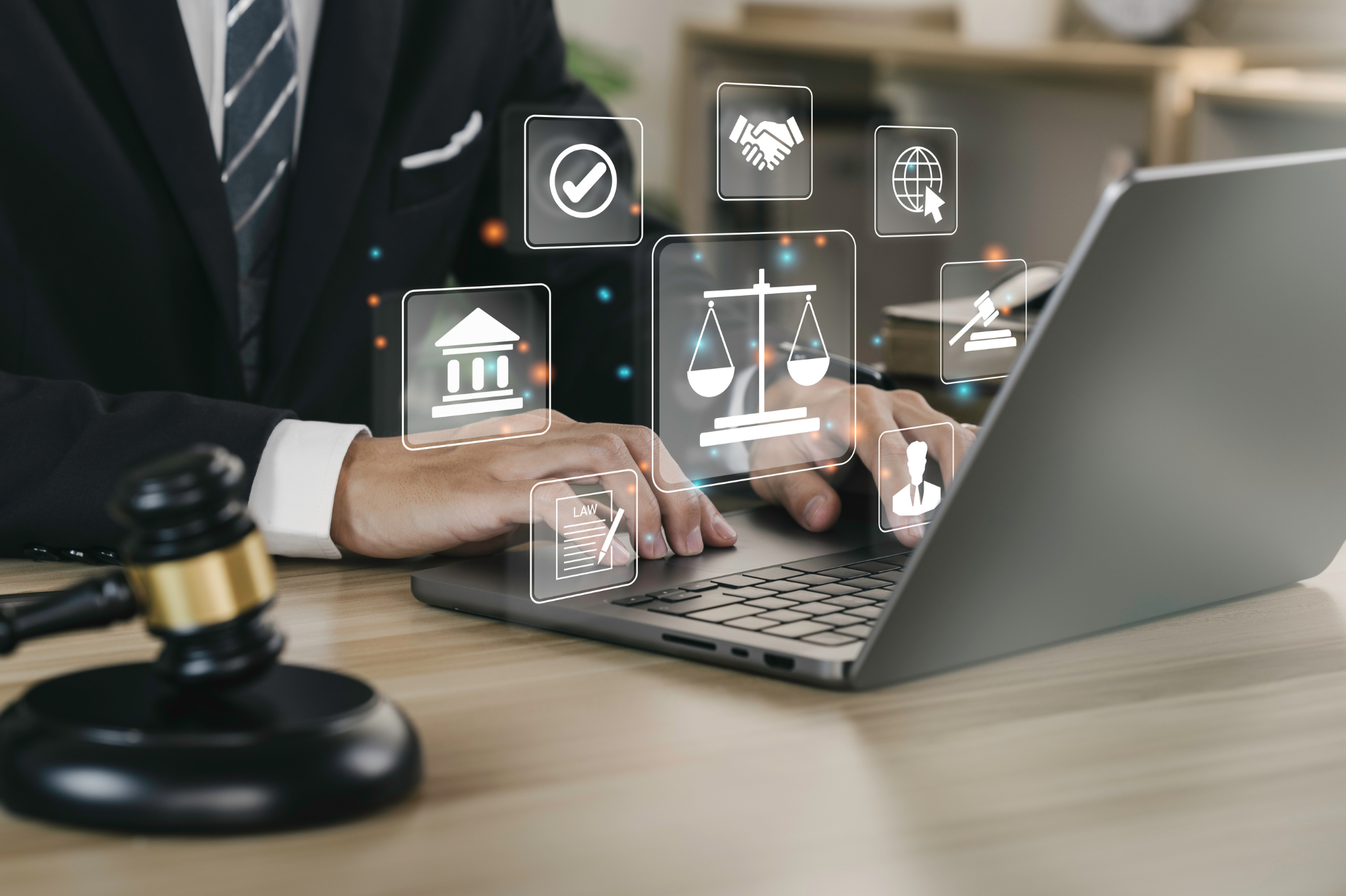 Person on a laptop with a gavel in the foreground and employment law icons hovering above keyboard