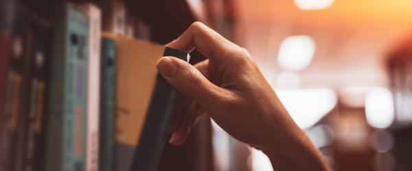 person grabbing a book